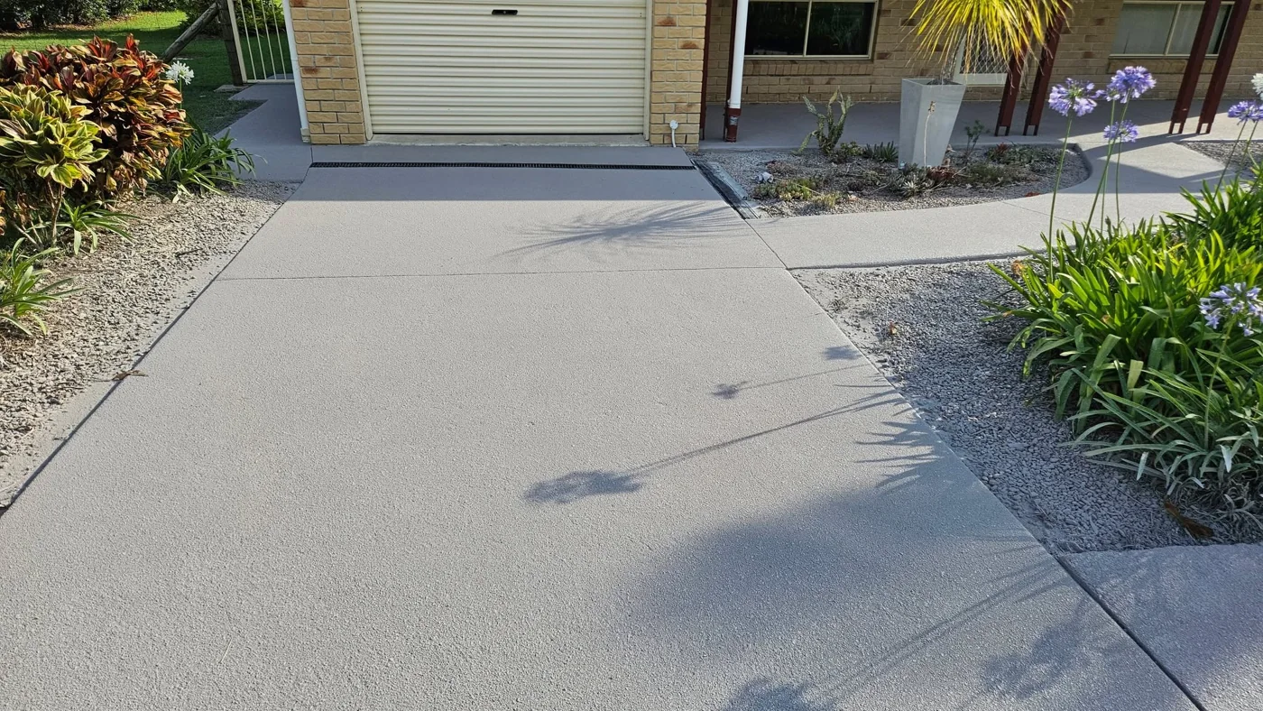 Finished grey resurfaced driveway contrasting with warm brickwork in Cooloola Cove