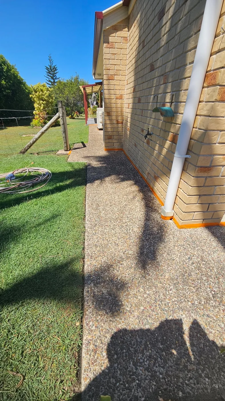 Before: exposed-aggregate path alongside the brick home