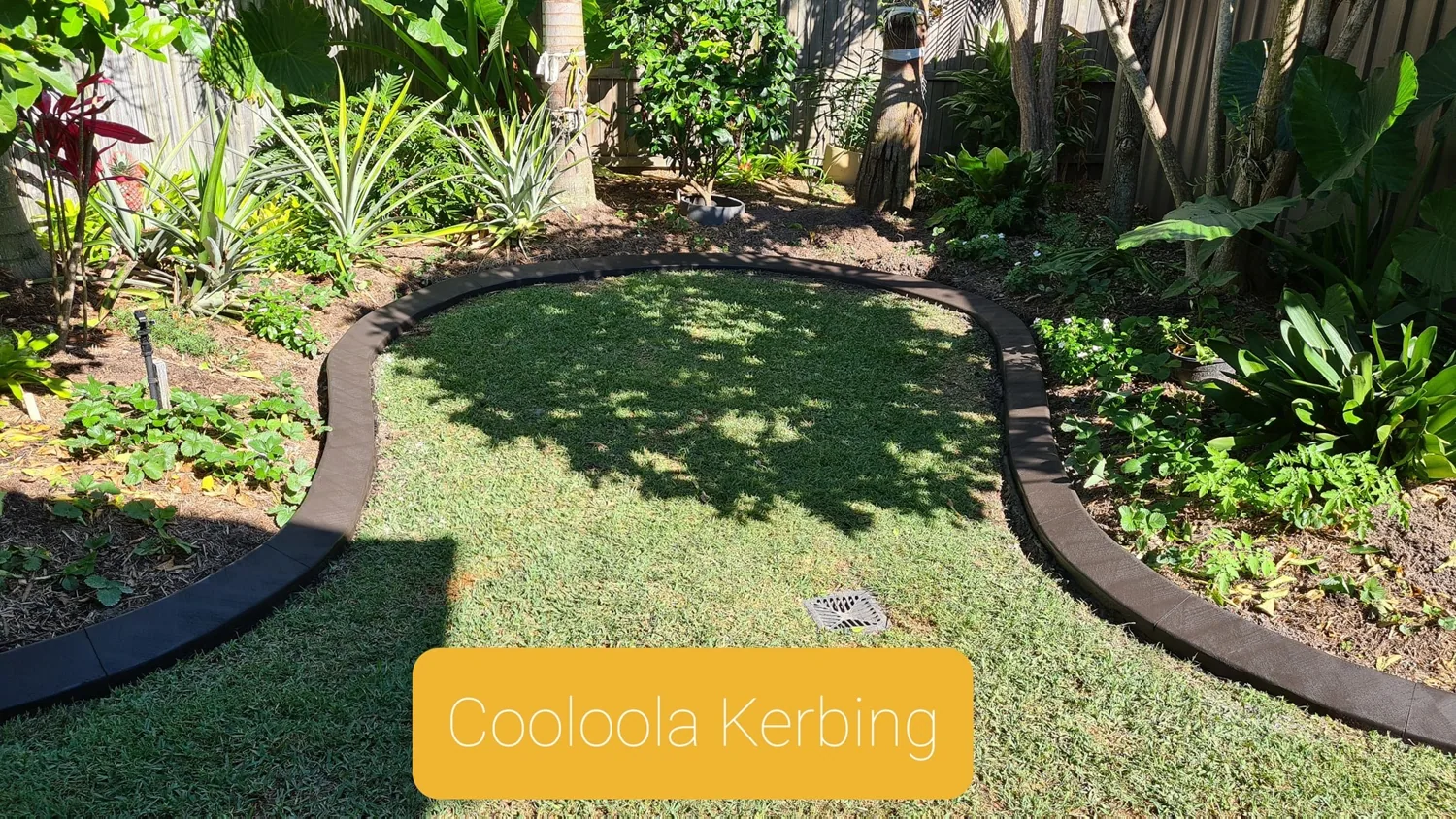 Continuous concrete edging separating grass from garden plants